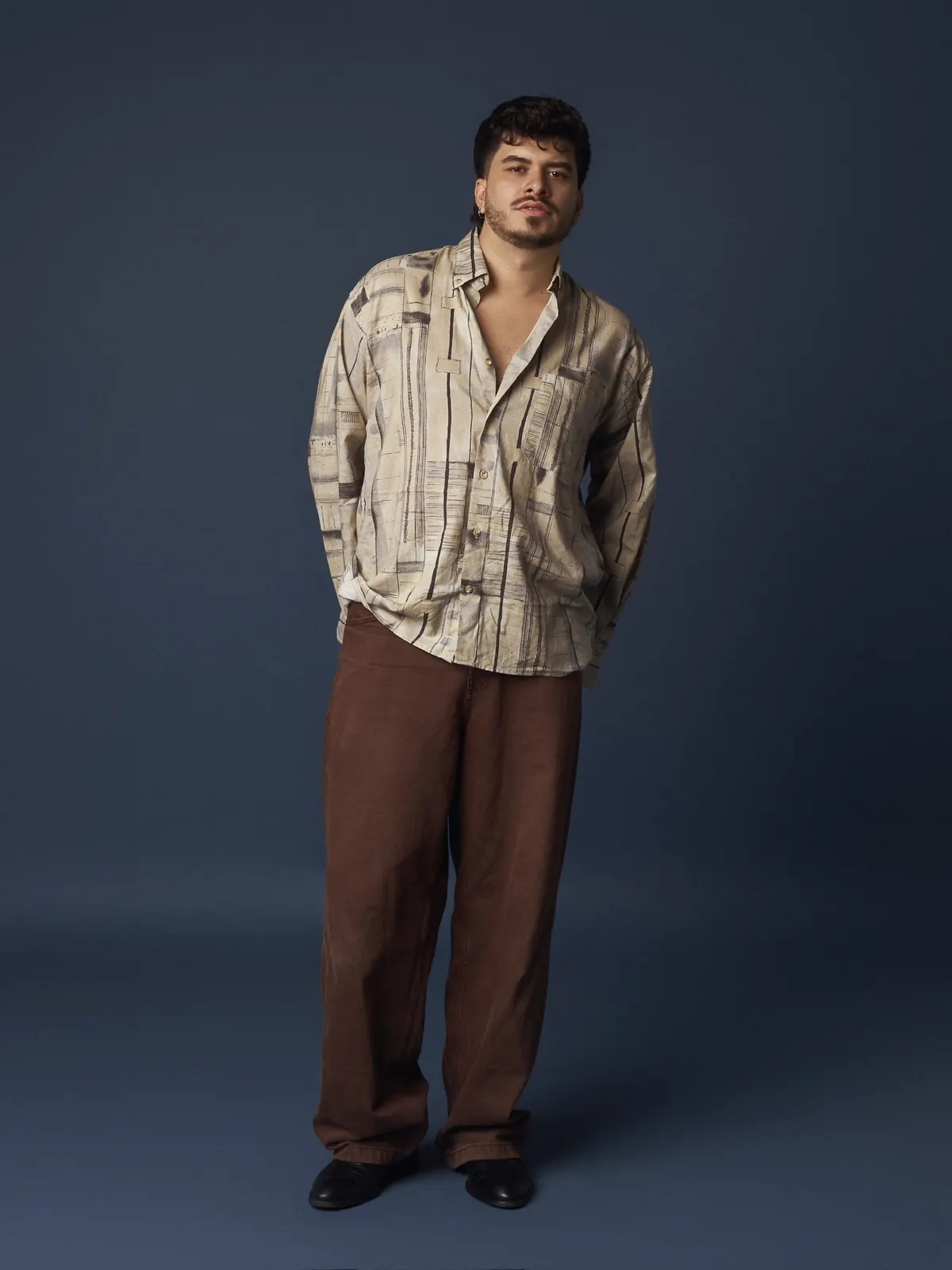 Iván Henríquez — camisa estampada sobre fondo azul, de pie