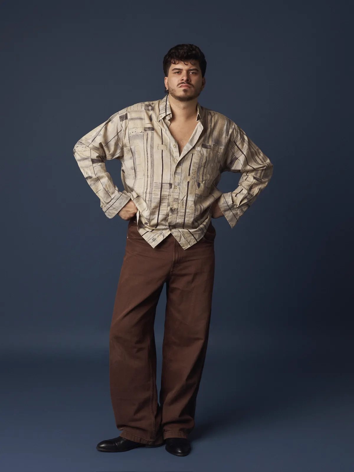 Iván Henríquez — camisa estampada, manos en la cintura y mirada a cámara