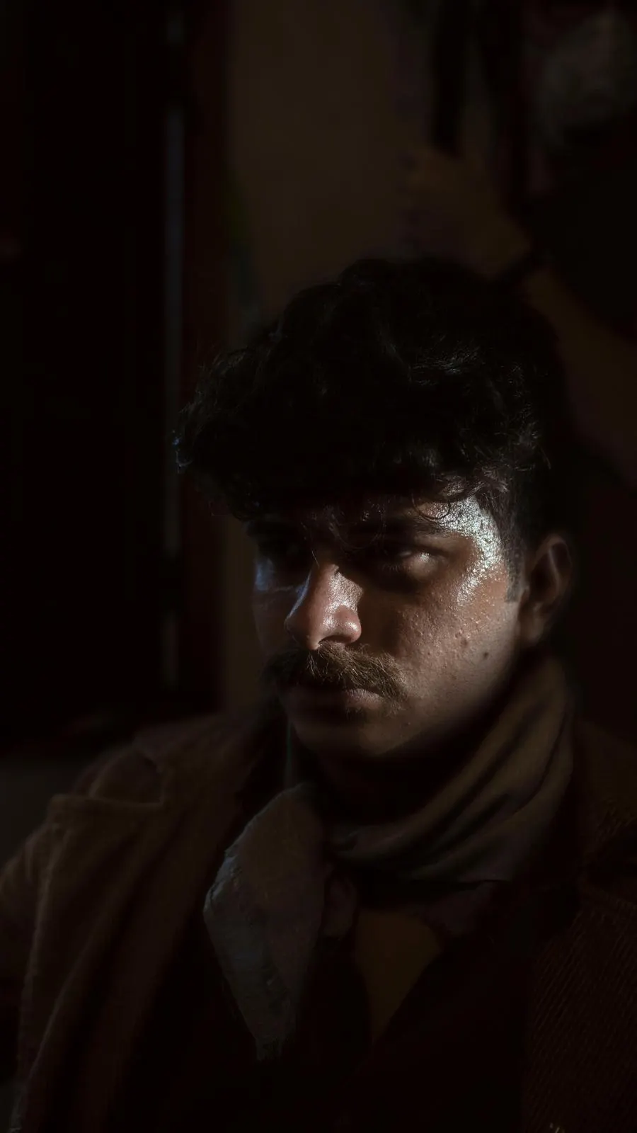Iván Henríquez en rodaje — fotograma en penumbra de un personaje de época